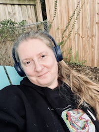 a woman with headphones sitting in a lawn chair